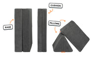 Four pieces of a charcoal gray Nugget play couch lined up: one foldable base, one foldable cushion, and two triangular pillows.