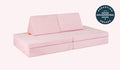 A Heartthrob blush pink Nugget play couch set up in a kids' sofa configuration.