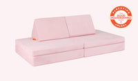 A Heartthrob blush pink Nugget play couch set up in a kids' sofa configuration.