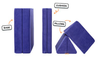 Four pieces of a vibrant indigo Nugget play couch lined up: one foldable base, one foldable cushion, and two triangular pillows.