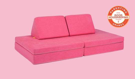 A Popstar hot pink Nugget play couch set up in a kids' sofa configuration.