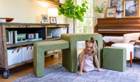 A child plays on the three pieces of a mossy sage Smore play chair.