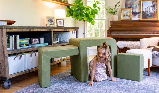 A child plays on the three pieces of a mossy sage Smore play chair.