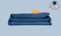 A neatly folded and stacked Smore Cover Set in navy blue Blueridge.