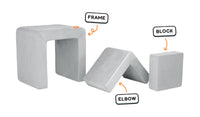 Four pieces of a light gray Smore play chair lined up: sturdy frame, one L-shaped elbow, and one square block.