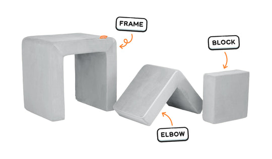 Four pieces of a light gray Smore play chair lined up: sturdy frame, one L-shaped elbow, and one square block.
