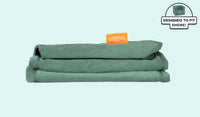 A neatly folded and stacked Smore Cover Set in sea green Seamonster.