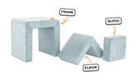 Four pieces of a light gray-blue Smore play chair lined up: sturdy frame, one L-shaped elbow, and one square block.