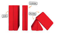 Four pieces of a true red Nugget play couch lined up: one foldable base, one foldable cushion, and two triangular pillows.