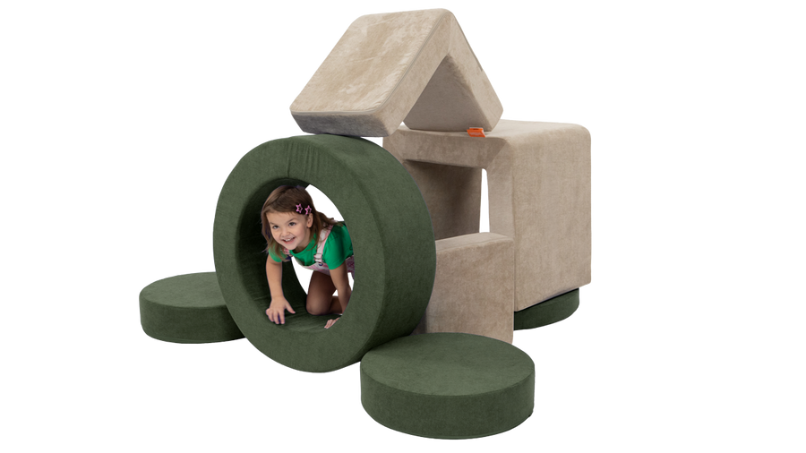 A child peeks out of the hoop of a Chunk while playing in a fort made from a beige Smore and forest green Chunk.