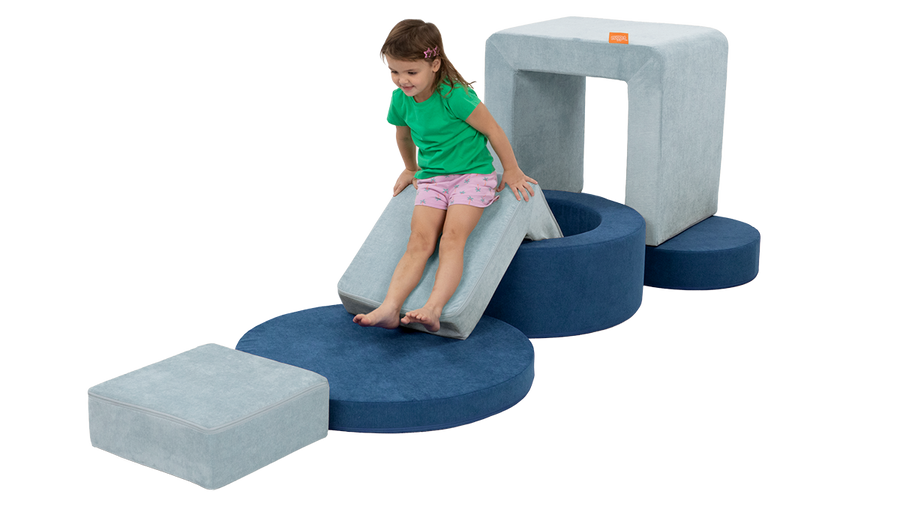 A child slides down the elbow of a light blue Smore, set up into an obstacle course with a navy blue Chunk.