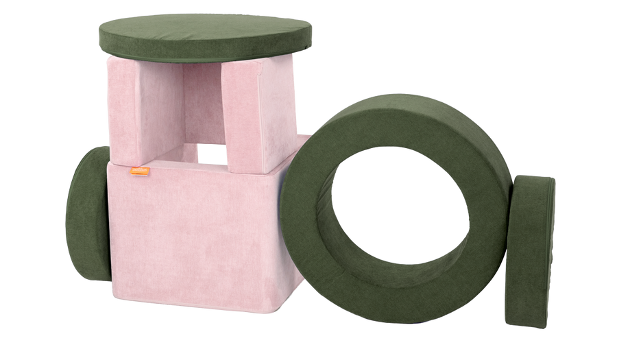 A forest green Chunk play ottoman and blush pink Smore play chair, arranged into a small fort.