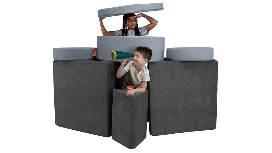 Two kids play in a foam play furniture submarine, built from one Nugget play couch and one Chunk play ottoman.