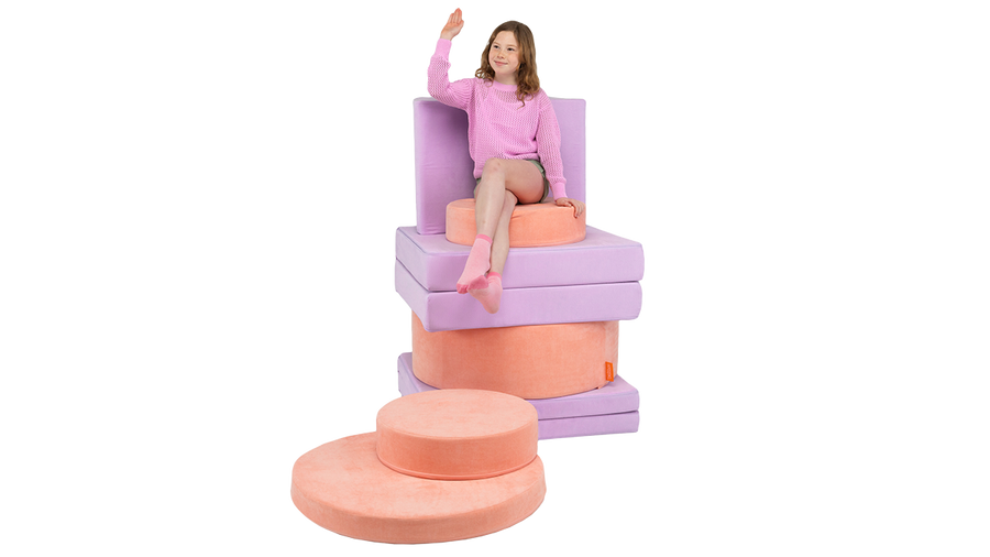 A child sits atop a colorful throne build, using one Nugget and one Chunk stacked up high.
