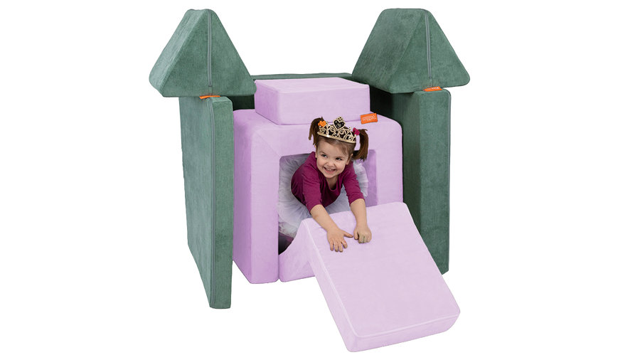 A child engaged in imaginative play inside a pretend castle, built from a Nugget play couch and Smore play chair.
