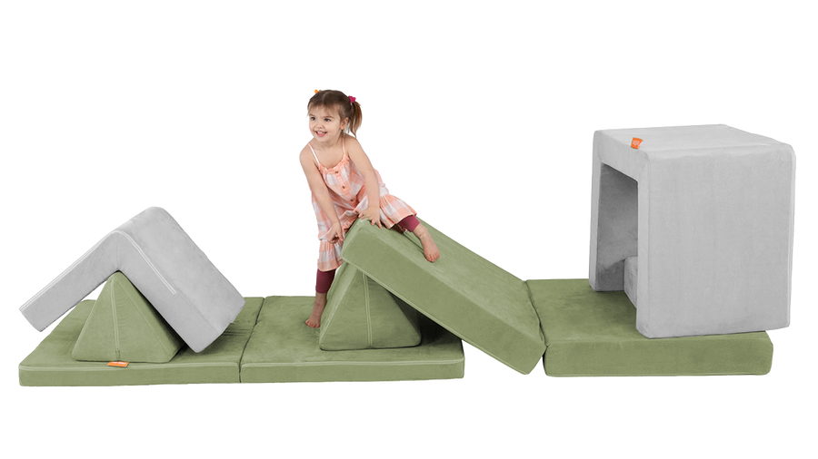 A child climbs on an obstacle course built from the pieces of a Nugget play couch and Smore play chair.
