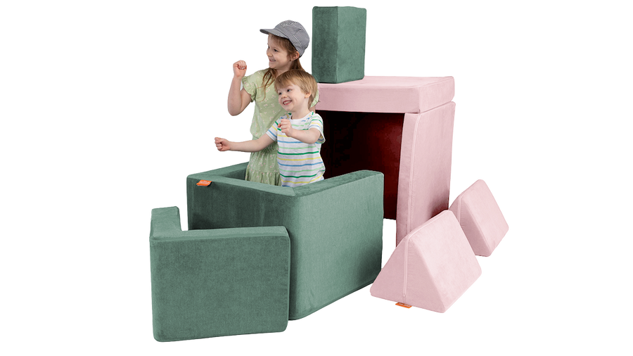 Two children pretend to sail a boat created from a pink Nugget play couch and sea green Smore play chair.