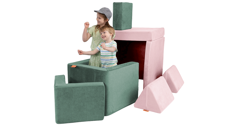 Two children pretend to sail a boat created from a pink Nugget play couch and sea green Smore play chair.