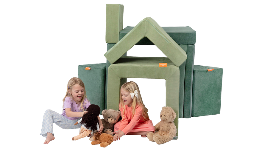 Two children play with stuffed animals in a cozy house built from the pieces of a sage green Smore play chair and sea green Nugget play couch.