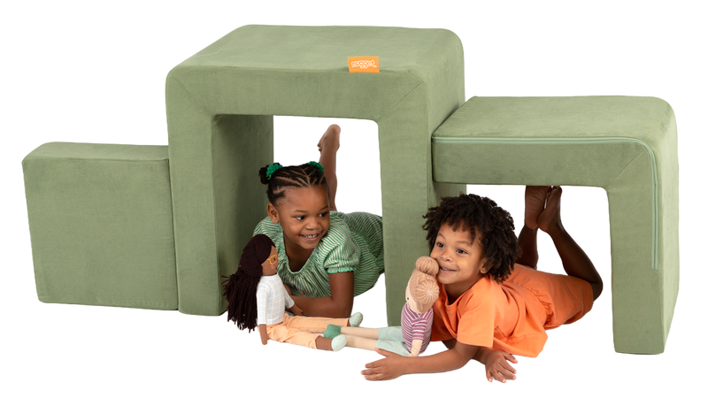 Two children play with dolls inside the pieces of a sage green Smore play chair by Nugget.