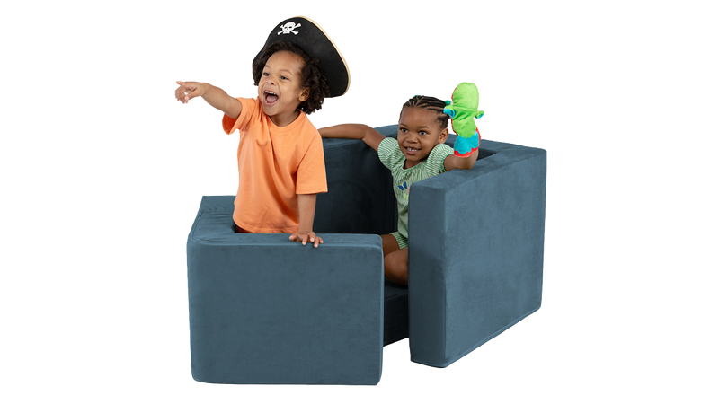 Two children pretend to sail in a pirate ship made from a navy blue Blueridge Smore play chair.