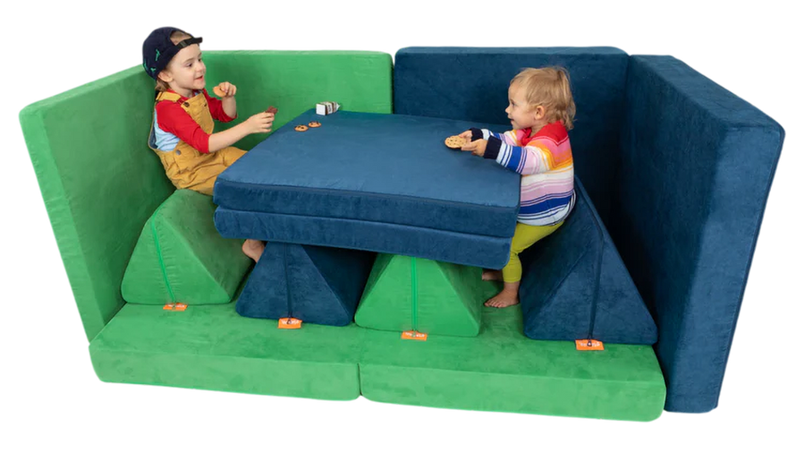 Two children have a snack at a diner booth build, constructed using two Nugget play couches.
