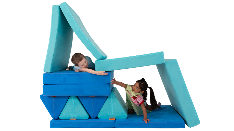 Two children hide and play in cozy cubbies constructed from two Nugget play couches, engaged in imaginative play.