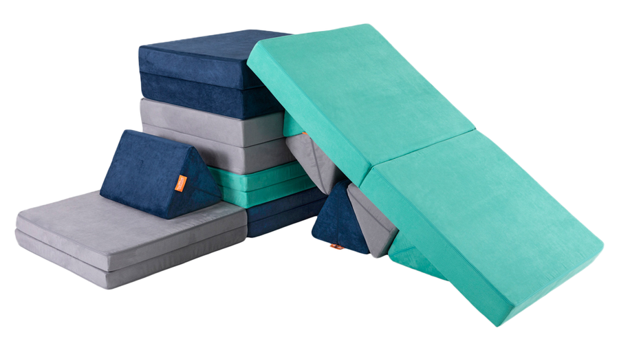 Three Nugget play couches are constructed into a tower with a cushion slide back down to the ground.