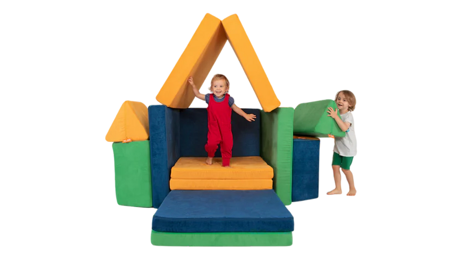 Two children play on a three-Nugget build resembling a colorful stage, built from three Nugget play couches.