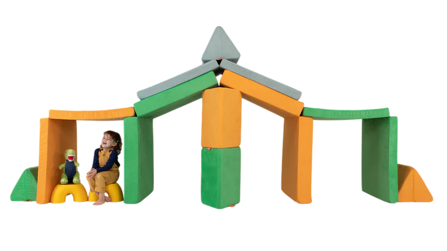 A child and her stuffed animal play in a three-Nugget build resembling a stable — ready for imaginative play.