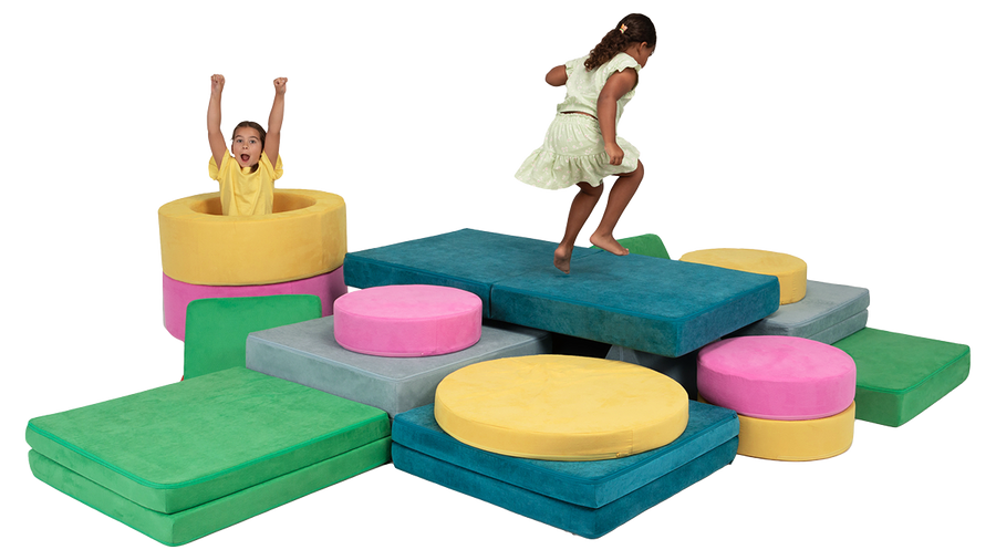 Two kids jump on a bright, colorful play furniture-build made from three Nugget play couches and two Chunk play ottomans.