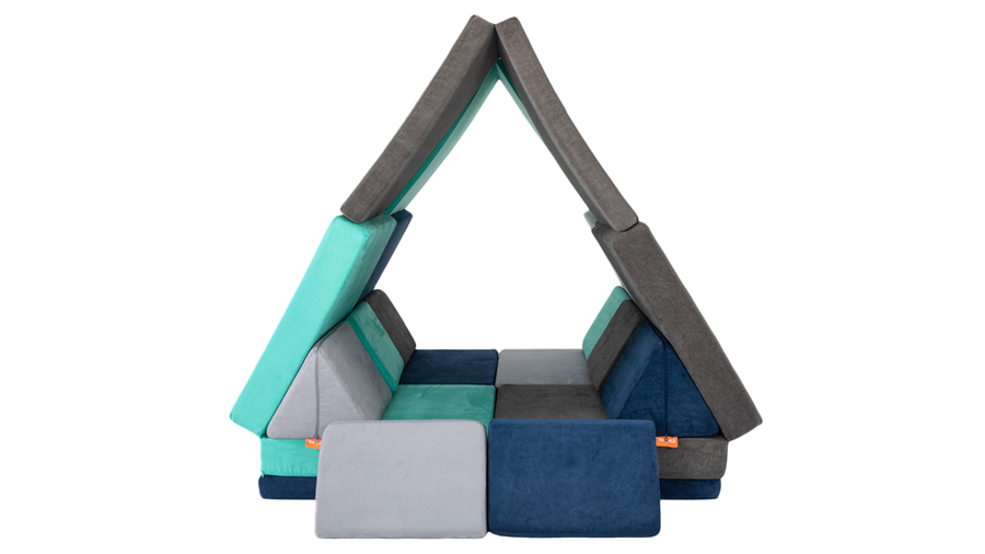 Four Nugget play couches are combined to form a Nugget fort resembling a giant tent, ready for imaginative play.