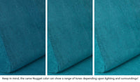 Close-up of a Nugget pillow in Atlantis peacock teal across three lighting situations. One color can present as a range of tones depending on the room.